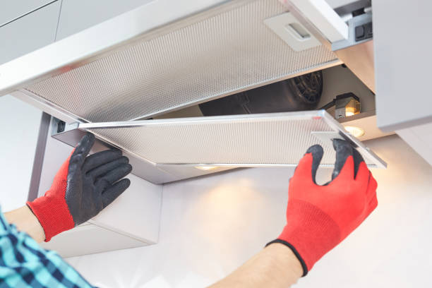 Male hands of an electrician troubleshoot a cooker hood.Cooker hood repair.