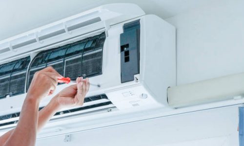 The technician under repairing the air conditioner by use screwdriver