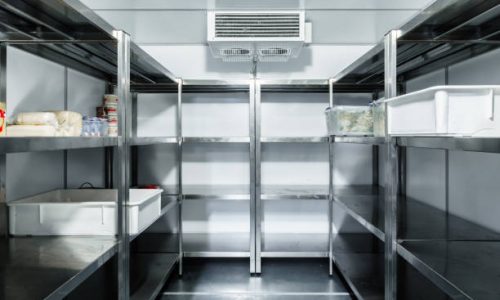 Refrigerator chamber with steel shelves in a restaurant close up